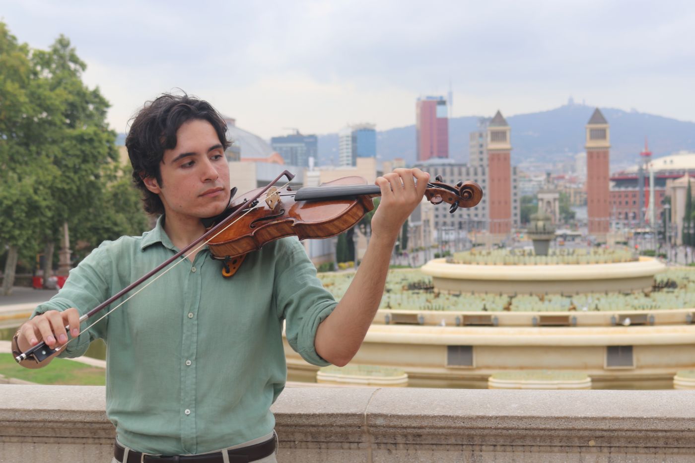 Arnau tocando el violín frente a la plaza de España, en Barcelona